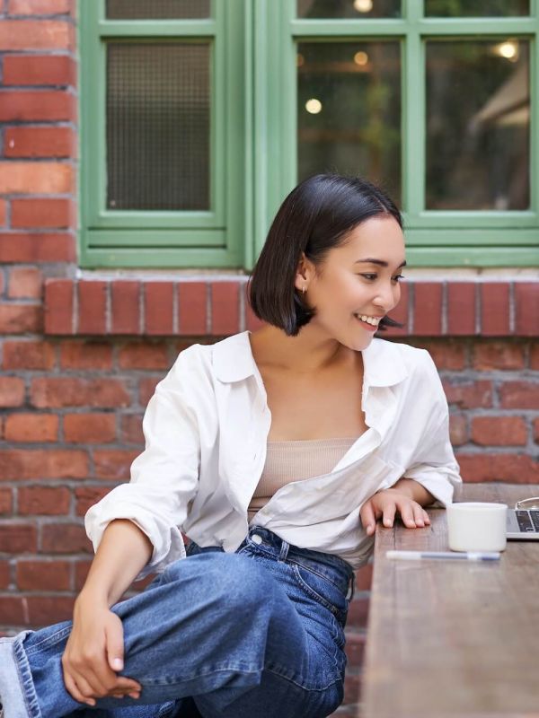 portrait-of-young-stylish-woman-influencer-sitting-in-cafe-with-cup-of-coffee-and-laptop-smiling.jpg